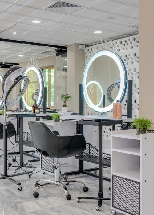 Elegant hair salon interior featuring sleek design and illuminated mirrors for a stylish beauty experience.